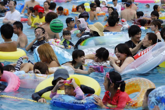 Visitors pack a giant pool at Toshimaen amusement park in Tokyo, Sunday, July 26, 2015. The temperature rose to 36 degrees Celsius (97 degrees Fahrenheit) in the Tokyo area.  Some 12,000 people are expected to visit the amusement park Sunday. (AP Photo/Shizuo Kambayashi